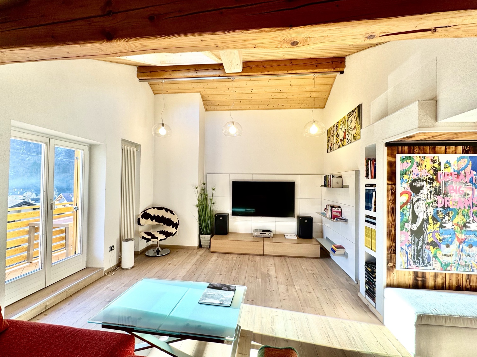 Wide view of the living room with exposed timber ceiling, Smart TV and sound system